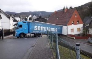 Şofer român nervos că nu are loc să vireze la stânga, dă cu spatele şi cade cu TIR-ul de pe şosea, în Germania