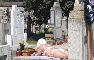 Imagini halucinante într-un cimitir din Alba Iulia. Femeie în costum de baie surprinsă făcând plajă pe piatra unui mormânt