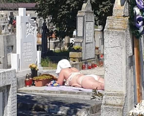 Imagini halucinante într-un cimitir din Alba Iulia. Femeie în costum de baie surprinsă făcând plajă pe piatra unui mormânt 