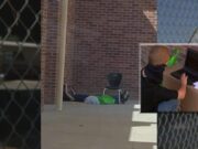 Un copil își face lecțiile pe trotuarul de lângă școala închisă pentru că e prea sărac să aibă internet acasă