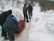 Mort tras cu sania prin zăpadă până la cimitir. Rudele au împins sicriul bunicii printre nămeți