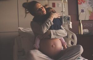 O mamă își ia rămas-bun de la copilul său mai mare, înainte să-i aducă pe lume frățiorul