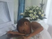 În mijlocul slujbei, copilul s-a ridicat în tăcere, s-a dus la sicriul mamei sale și a lipit urechea de el. Apoi s-a întors spre ceilalți oameni prezenți la înmormântare și a spus un singur lucru care i-a făcut să ÎNGHEȚE pe loc, în biserică😢– >>