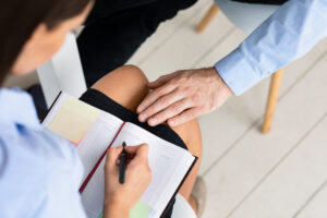 Businessman Harassing Woman Touching Her Knee Sitting In Office, Cropped