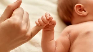 faceless-mother-with-naked-baby-infant-holding-mommy-s-finger-mum-spending-time-with-her-tiny-child-light-background-scaled